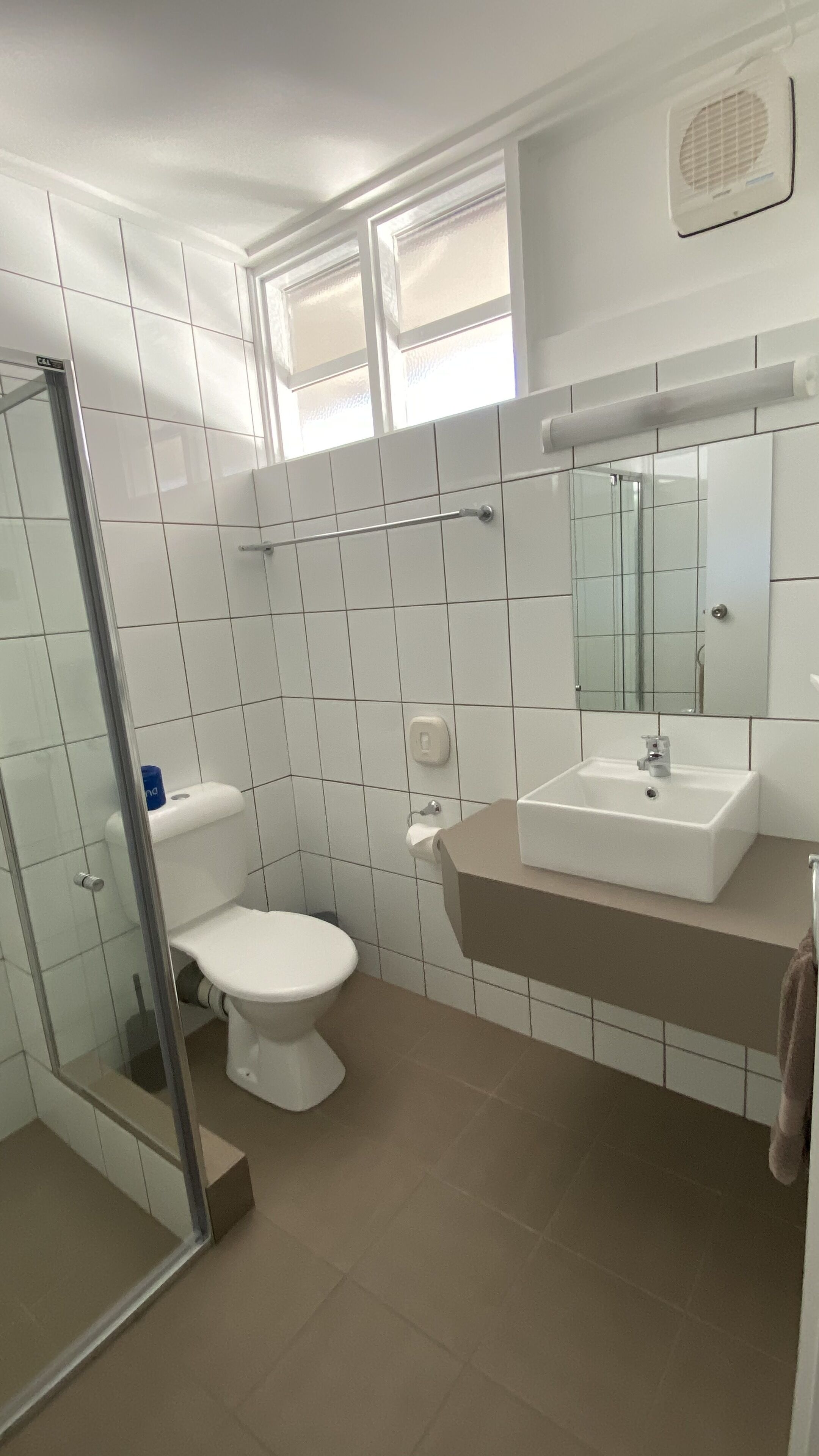 A bathroom with a toilet, sink, and shower.