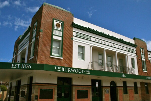 El Burwood Inn, un edificio histórico con fachada blanca y detalles en verde, establecido en 1876.