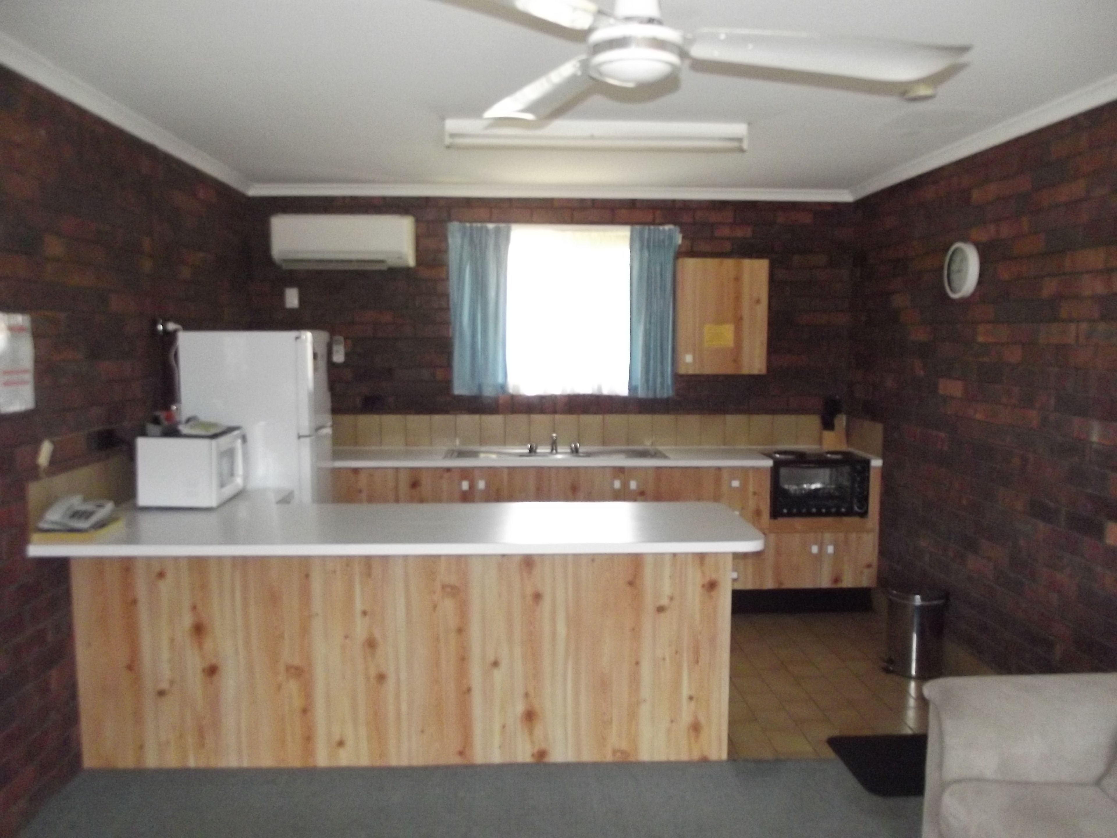 A compact kitchen with a central island, a built-in oven, and a microwave.