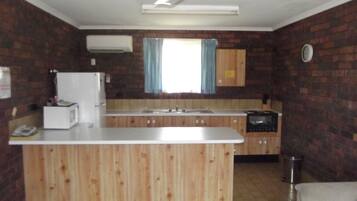 A compact kitchen with a central island, a built-in oven, and a microwave.