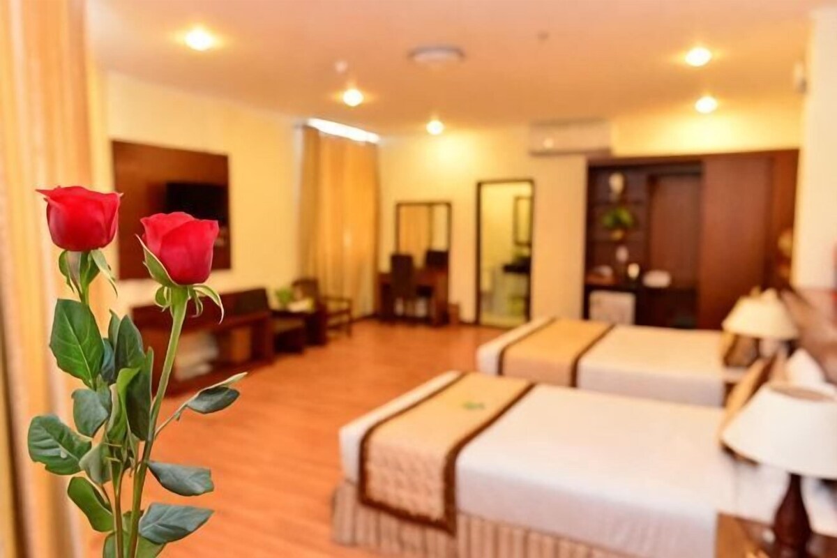 Una habitación de hotel con una cama, un escritorio y un espejo.