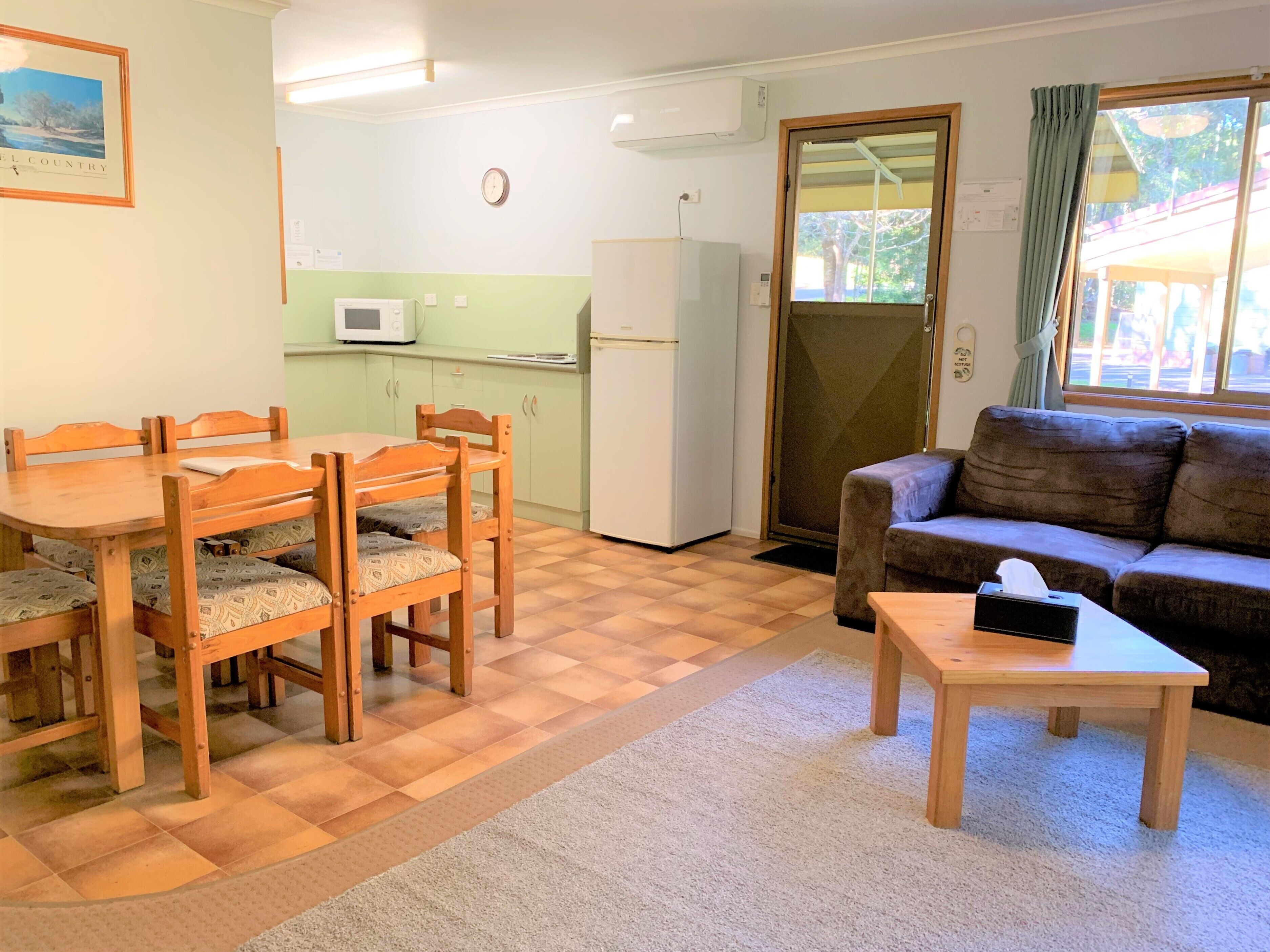 A compact living space with a dining area, kitchenette, and a sofa.