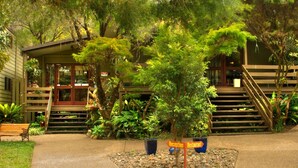 A reception area with a staircase leading to a building, surrounded by lush greenery and potted plants. - Broken River Mountain Resort (Broken River)