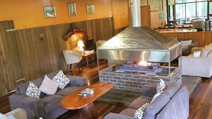 A spacious lounge area with sofas, a coffee table, and a fireplace. - Broken River Mountain Resort (Broken River)