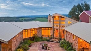 A large, modern building with a curved roof, a stone exterior, and a well-lit entrance. - Cape Otway Cottages (Hordern Vale)