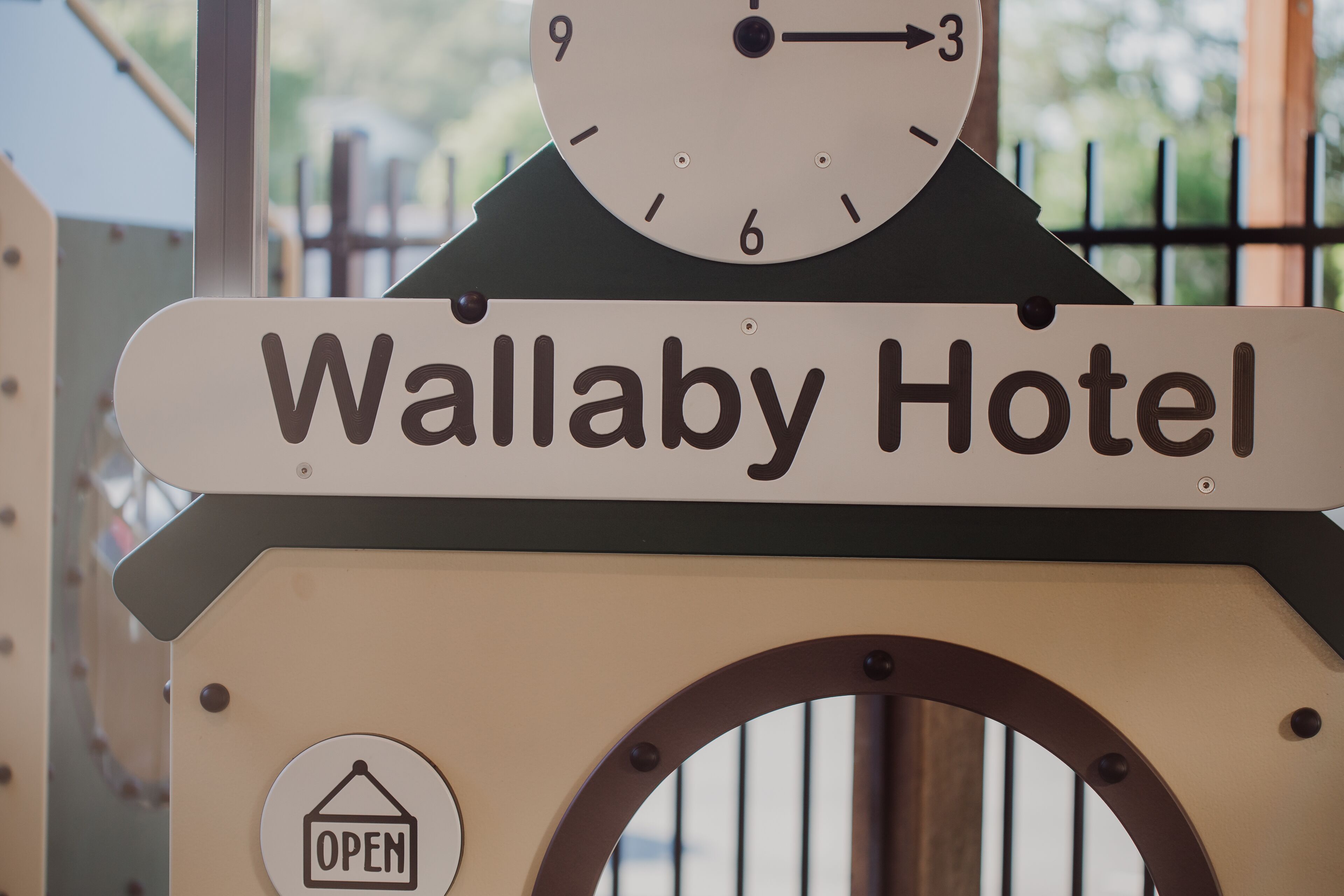 Um relógio e uma placa com o nome Wallaby Hotel.