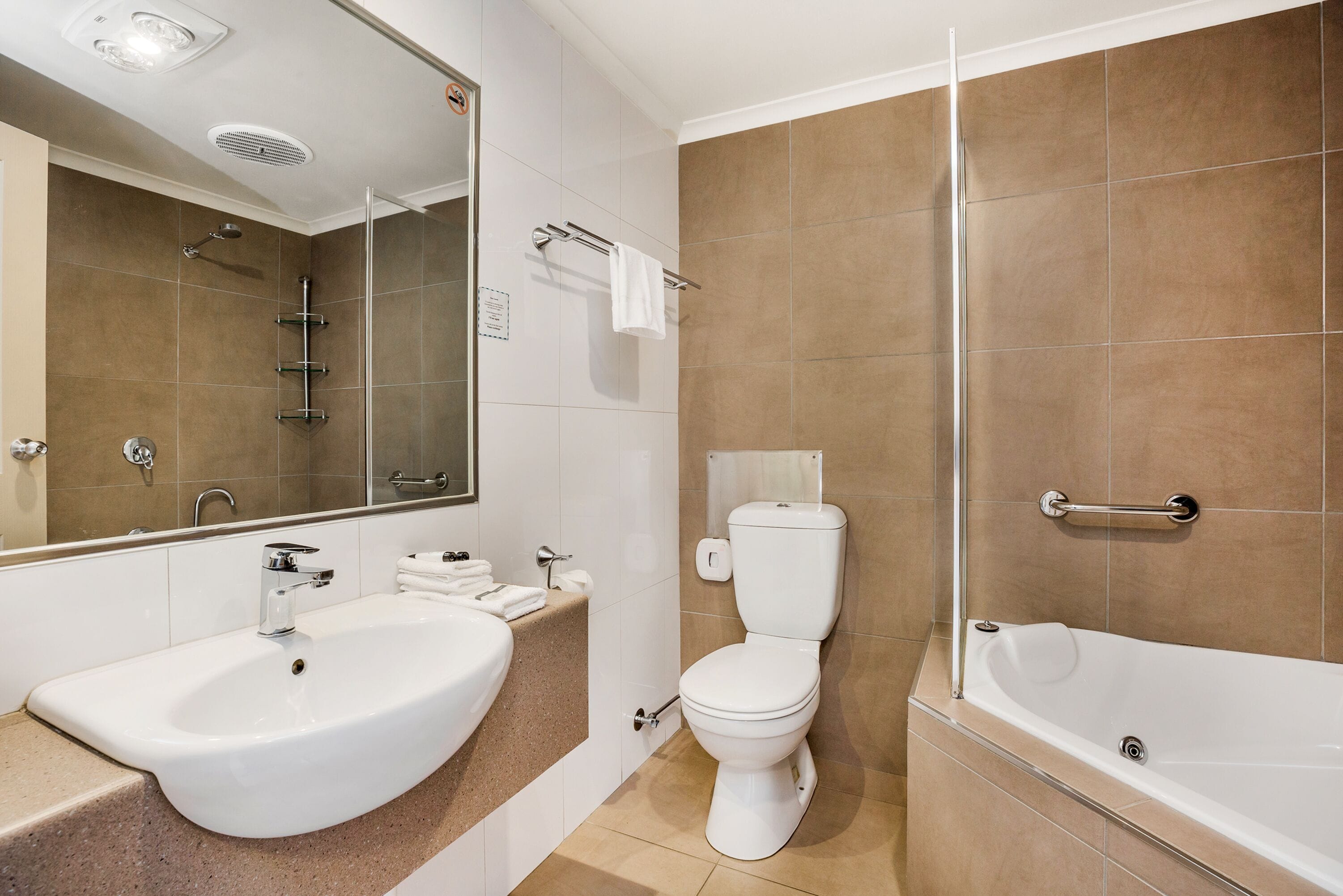 A modern bathroom with a sink, toilet, and bathtub.