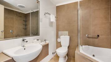 A modern bathroom with a sink, toilet, and bathtub.