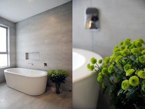 A modern bathroom with a freestanding bathtub, a small potted plant, and a wall-mounted light fixture. - Relbia Lodge (Relbia)