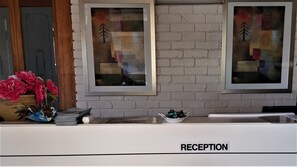 En receptionsdisk med en skylt som det står ”RECEPTION” på, i en hotellobby.
