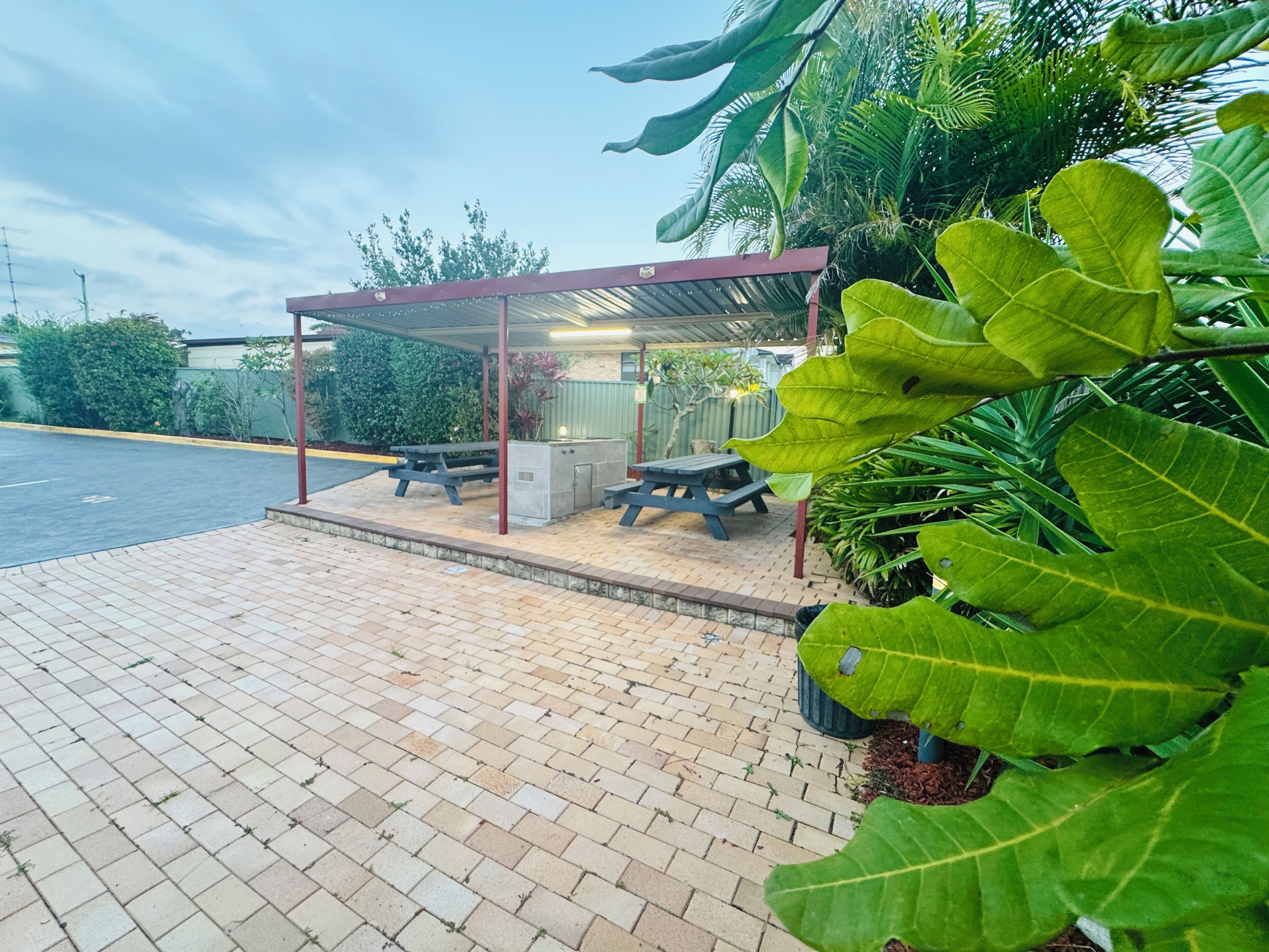 A covered outdoor seating area with picnic tables and a sheltered structure.