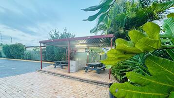 A covered outdoor seating area with picnic tables and a sheltered structure.