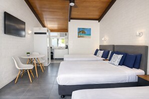 A modern room with a bed, a desk, and a chair.