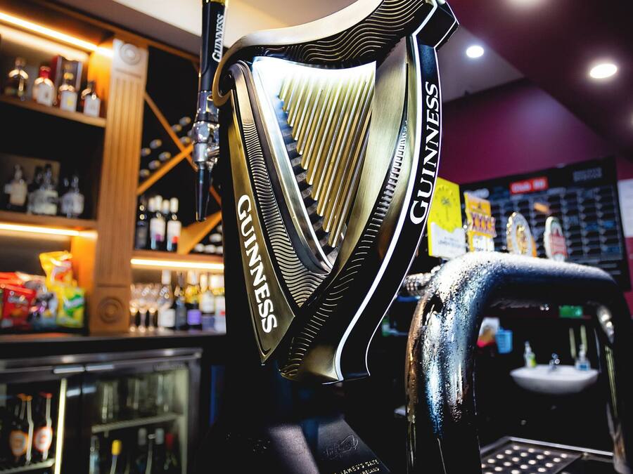 Eine Barbereich mit einem Guinness-Zapfhahn und einer Auswahl an Flaschen im Hintergrund.