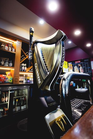 A bar area with a Guinness branded tap and a selection of bottles in the background. - Doctor Syntax Hotel (Sandy Bay)