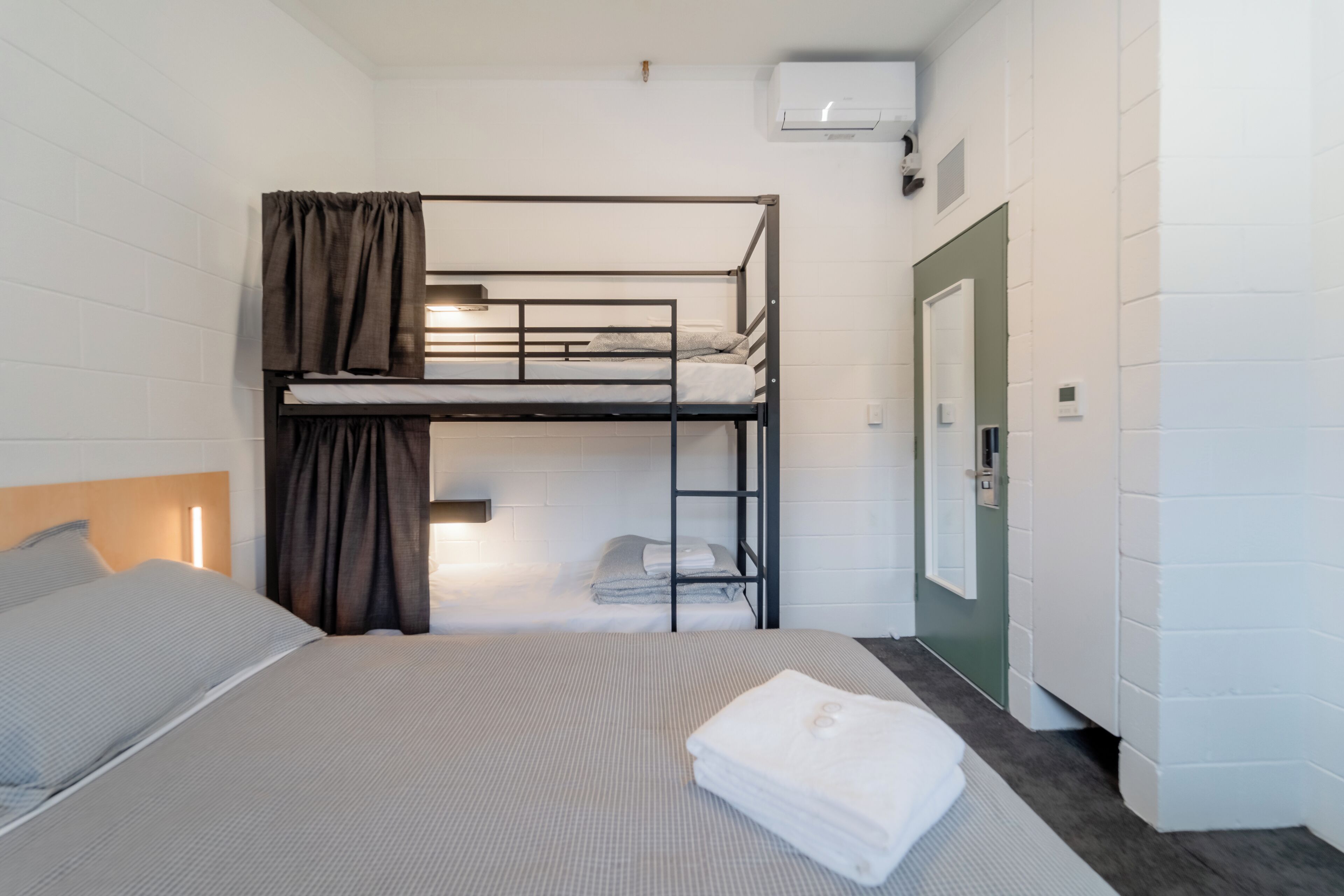 Una camera con un letto a castello, una scrivania e un armadio.