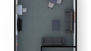 Una habitación con una mesa de comedor, un sofá, un mueble pequeño y un inodoro.