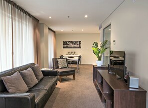 Departamento Deluxe, 2 habitaciones | Sala de estar | Televisión de pantalla plana y reproductor de DVD 