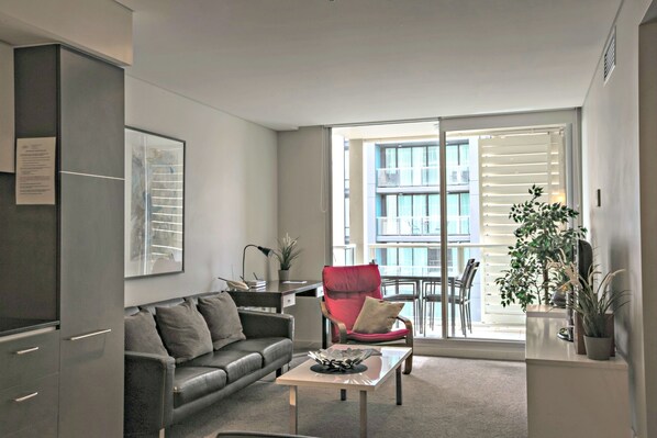 Departamento Deluxe, 2 habitaciones | Área de sala de estar | Televisión de pantalla plana y reproductor de DVD 