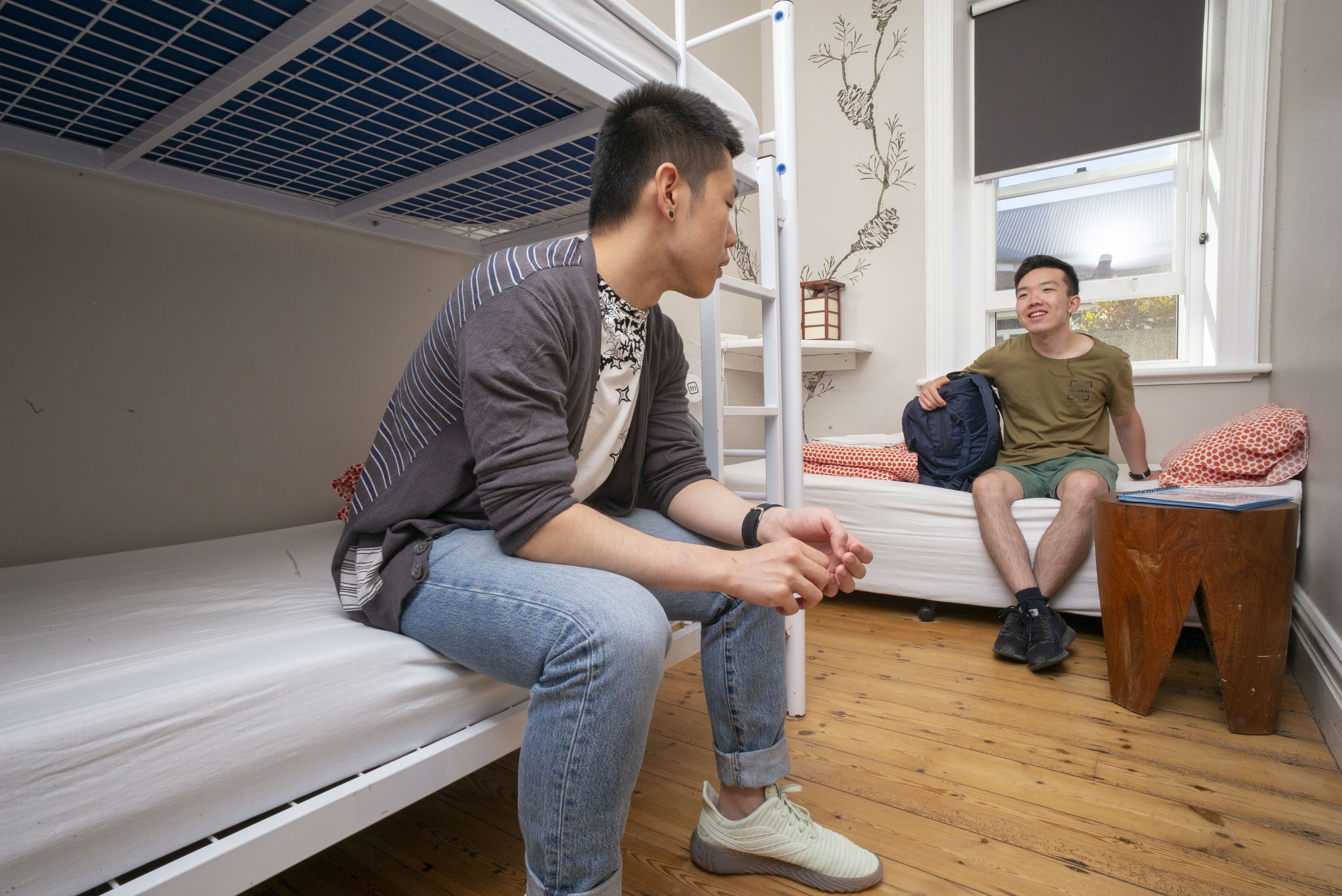 Un dormitorio con literas, suelo de madera y ventana con vistas.