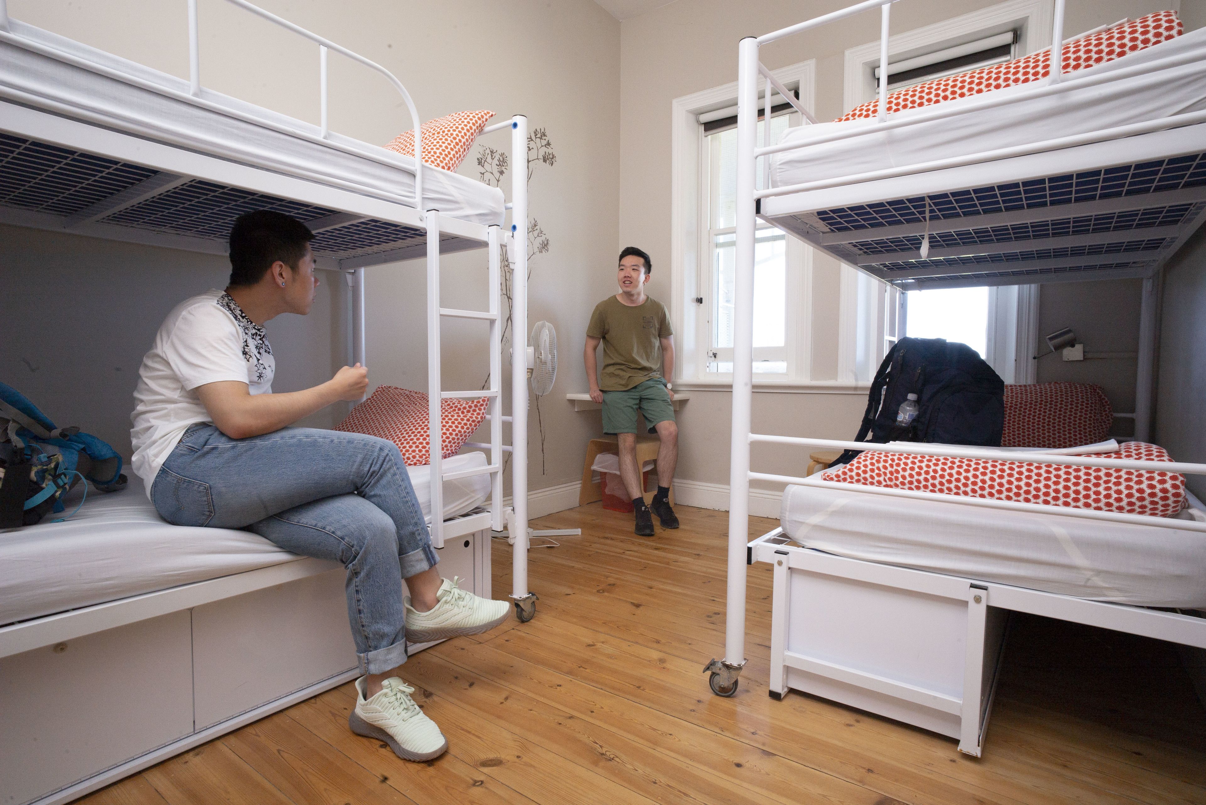 Un dormitorio con literas, un ventilador y una ventana.