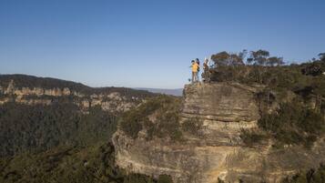 A large rock formation with a clear view of the surrounding forest and distant hills.