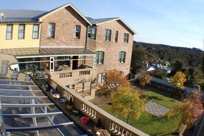 Relax in the serene surroundings of this building, featuring a glass conservatory with outdoor seating and potted plants.