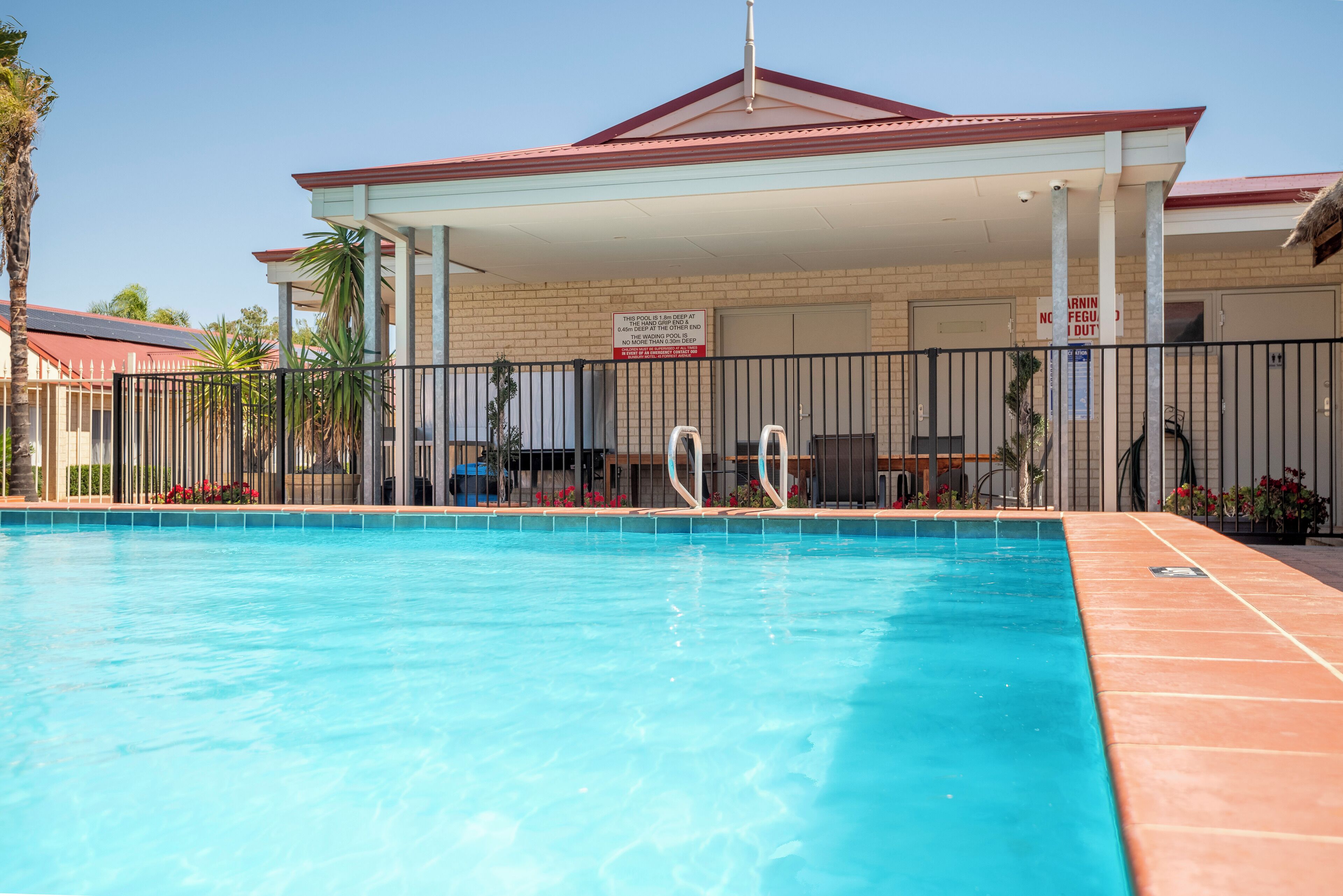 Een buitenzwembad en ligstoelen