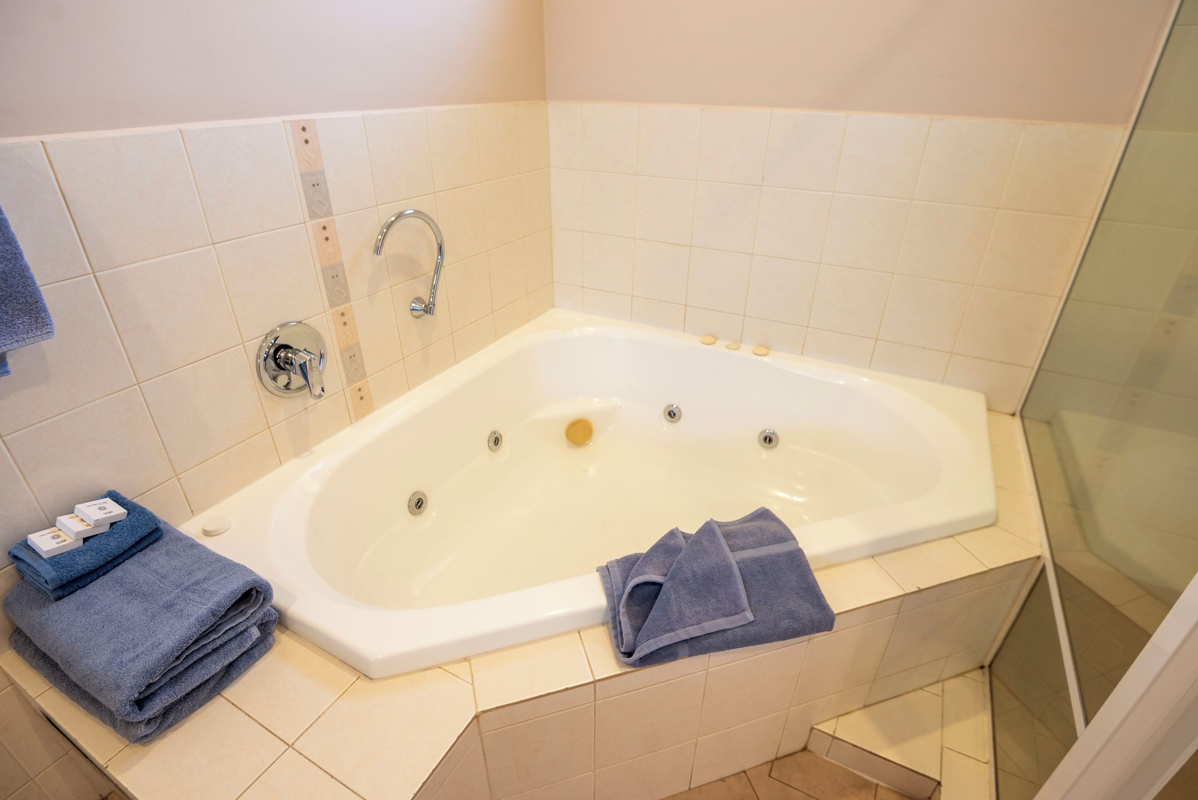 Ein Badezimmer mit Badewanne, Dusche und Toilette. Auf dem Ablagetisch liegen Handtücher und Toilettenartikel.