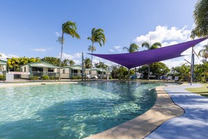 Una piscina al aire libre, sillones reclinables de piscina