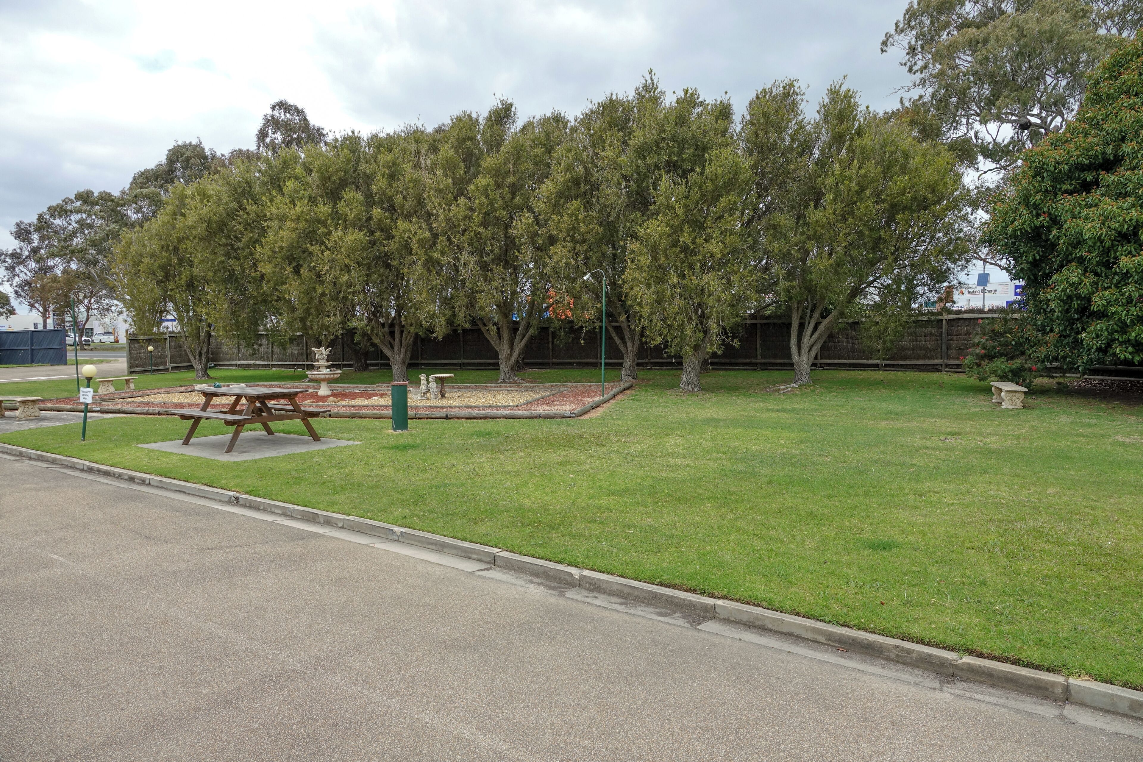 A park with picnic tables, benches, and a fountain.