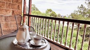 A balcony with a table set for tea, featuring a teapot, cups, and saucer. - The Abbey (Warwick)