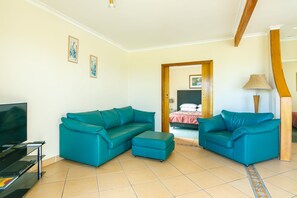 Apartamento estándar, 2 habitaciones, frente al mar (upstairs) | Zona de estar | Una televisión de pantalla plana, un reproductor de DVD