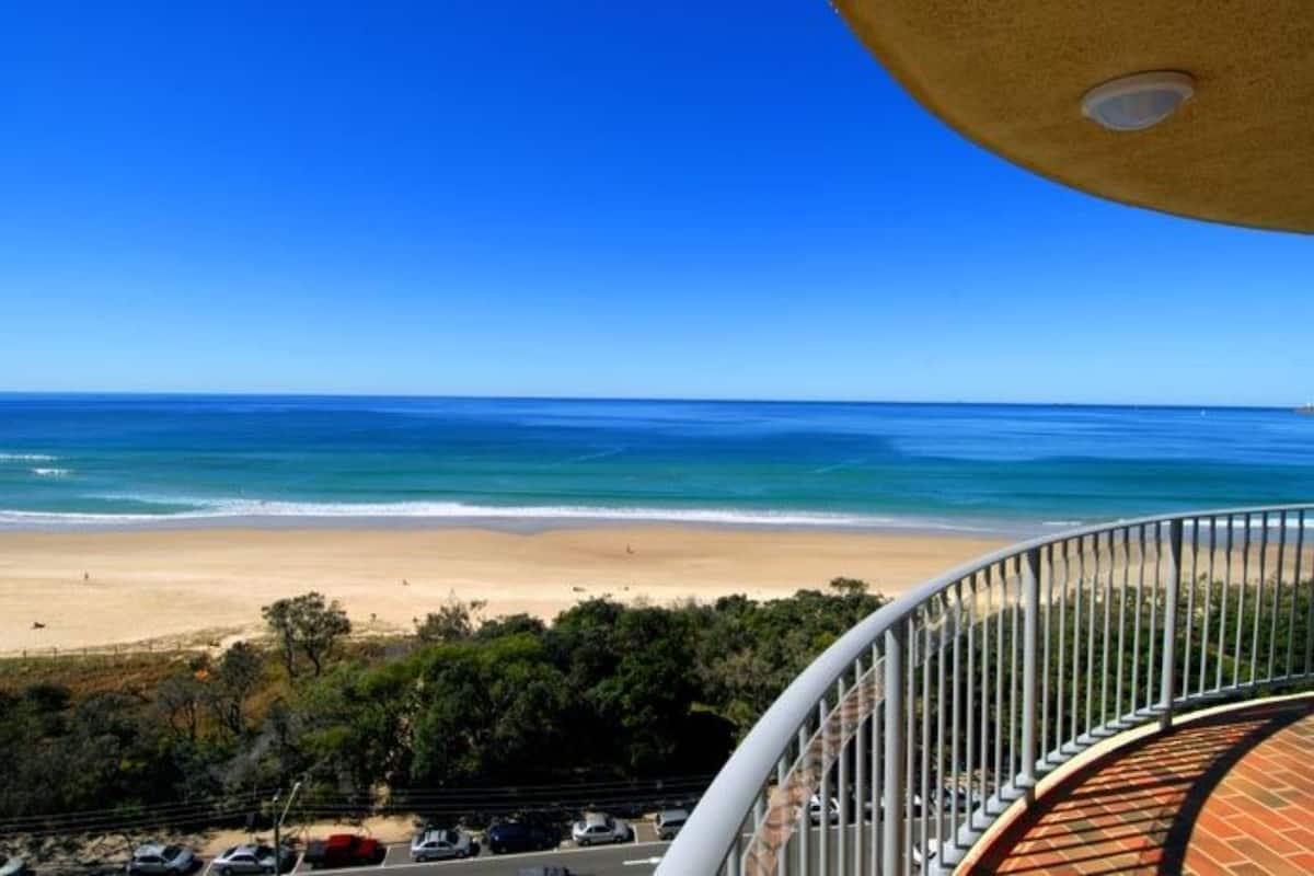 Een balkon met uitzicht op een strand en zee.
