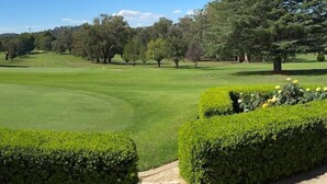 A well-maintained golf course with neatly trimmed hedges and a clear path leading to the tee area. - Cowra Crest Motel (Cowra)