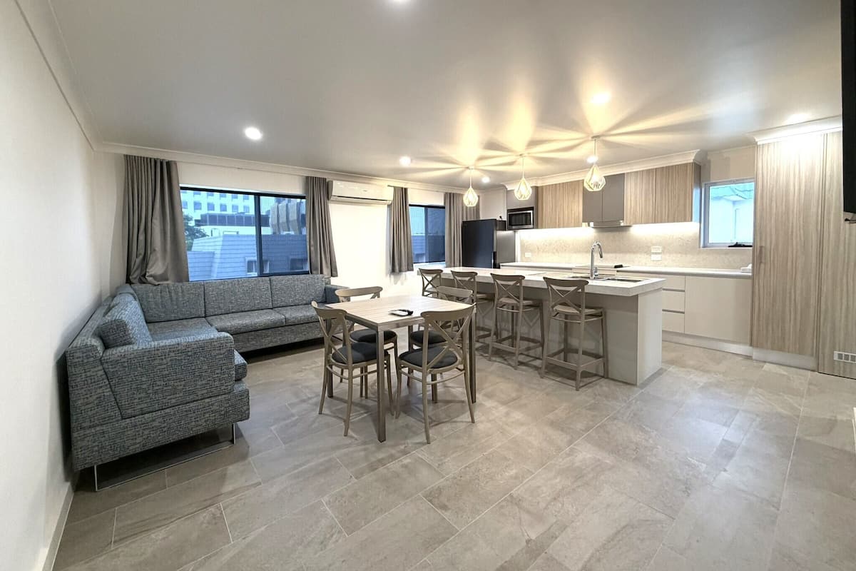 A modern apartment with a dining area, kitchen, and living room.