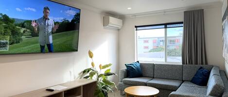 A living room with a TV, sofa, and a small table.