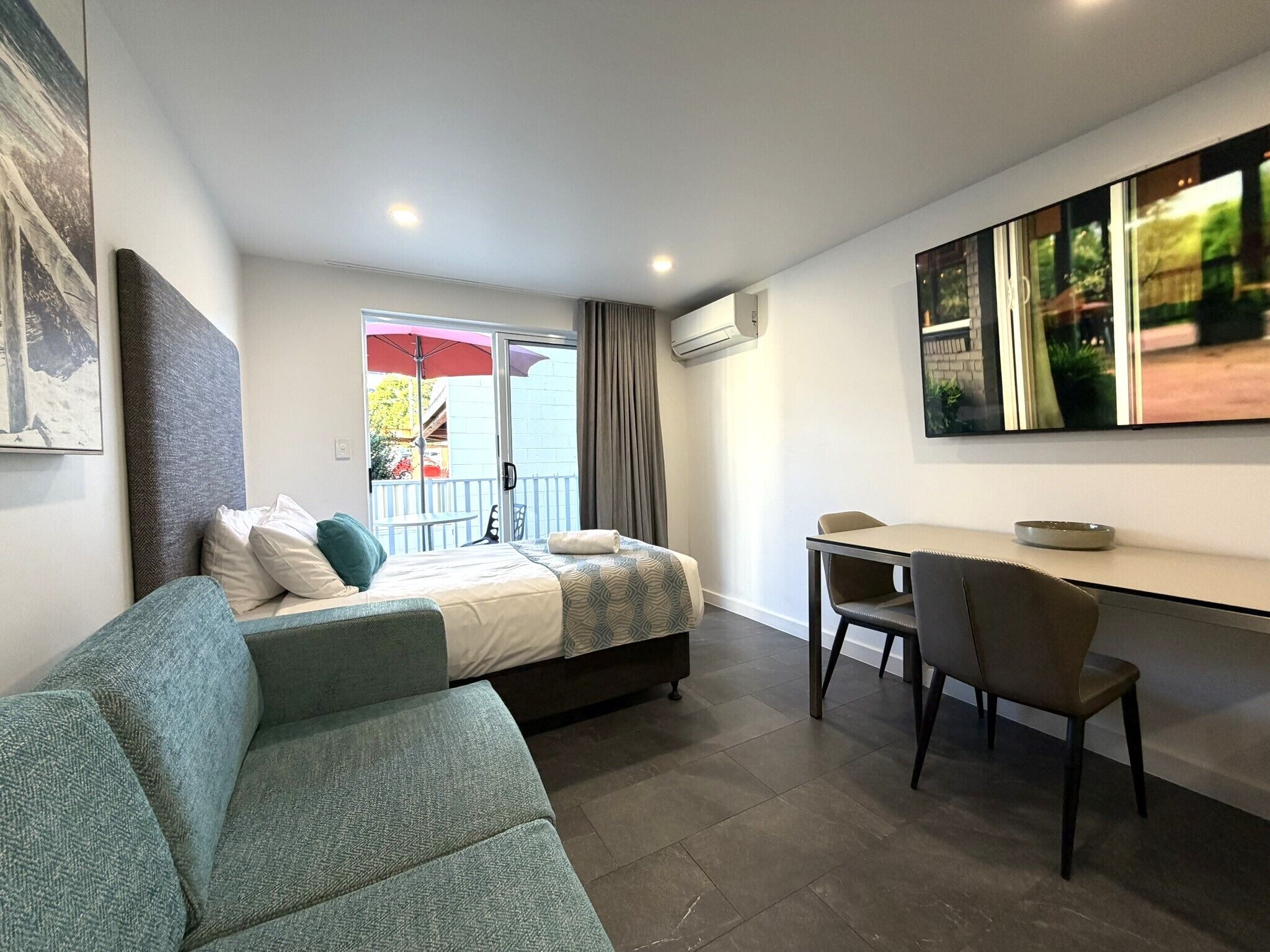 Une chambre moderne équipée d’un lit, d’un canapé, d’un bureau et d’une télévision.