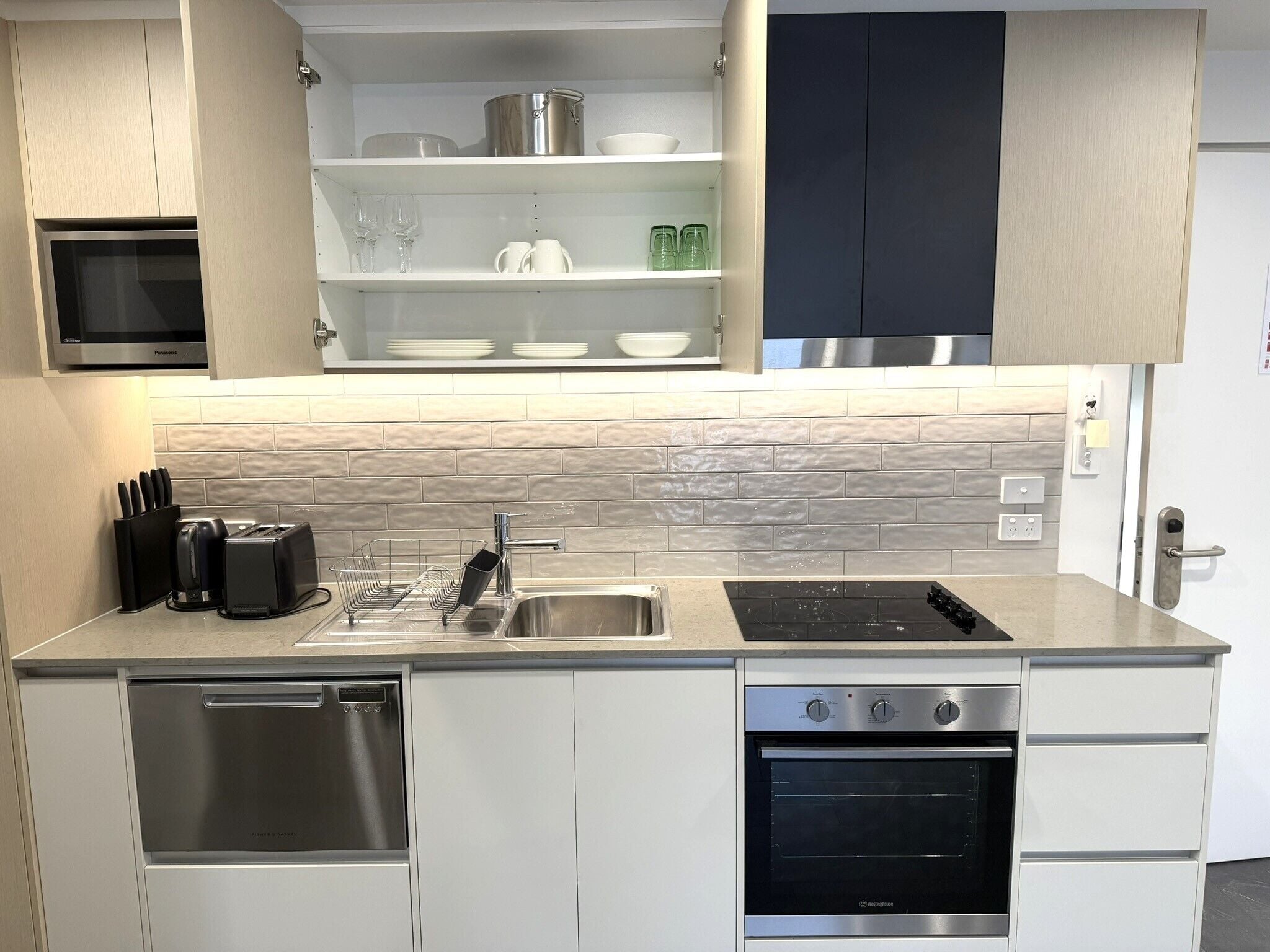 A modern kitchen with a dishwasher, oven, and built-in microwave.