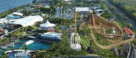 An aerial view of a theme park with roller coasters, water attractions, and various buildings.