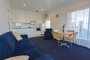 One Bedroom Apartment | Living area | 32-inch LCD TV with digital channels, TV, books - Heyfield Motel & Apartments (Lakes Entrance)