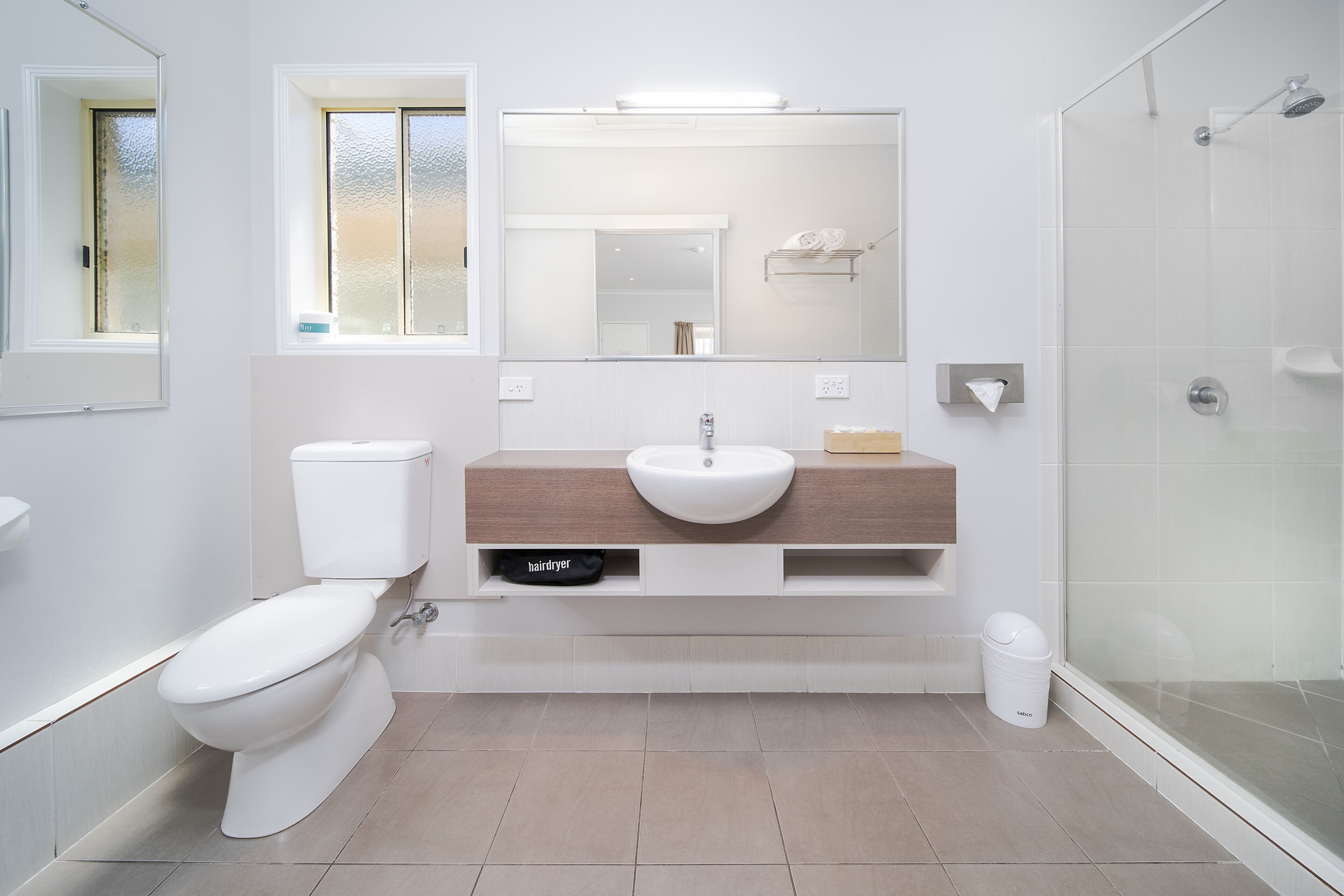 A modern bathroom with a toilet, sink, and shower.