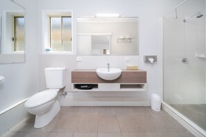 A modern bathroom with a toilet, sink, and shower.