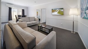 A modern living room with a beige sofa, a coffee table, and a floor lamp.