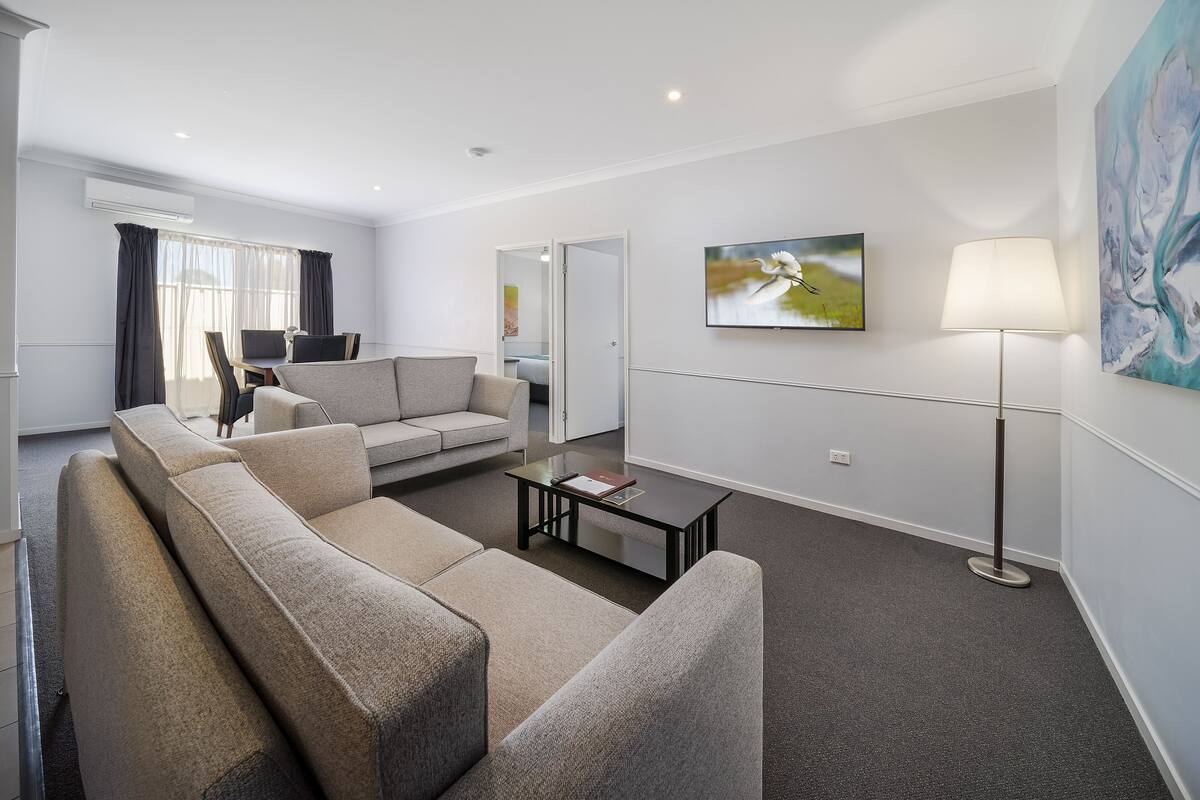 A modern living room with a beige sofa, a coffee table, and a floor lamp.