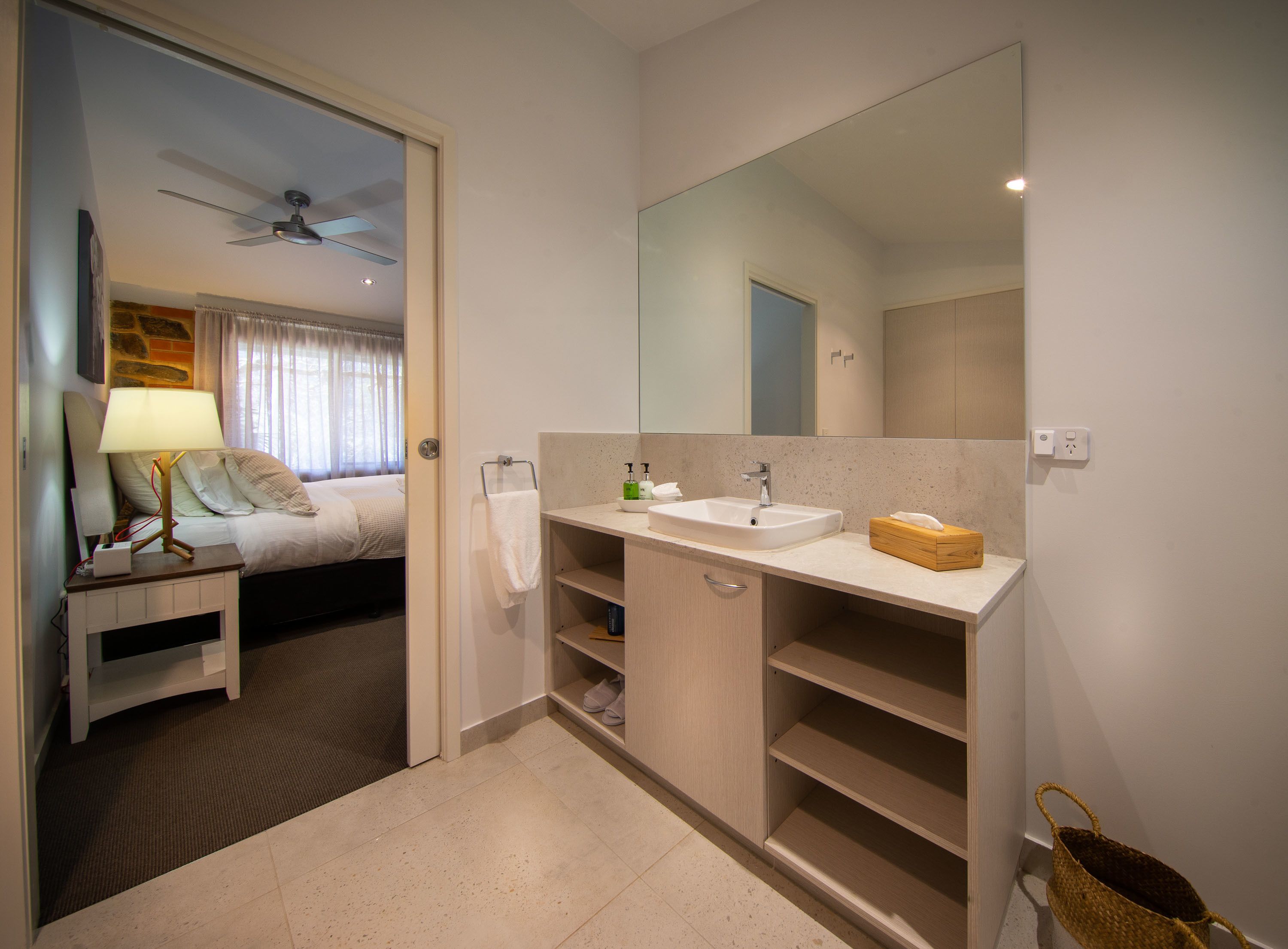 A modern bathroom with a large mirror, a sink, and a vanity.