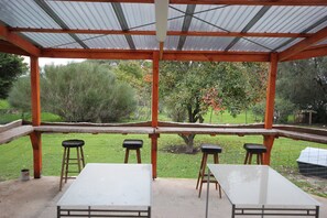 Enjoy dining or socializing in this garden area with a metal roof and comfortable seating for four.
