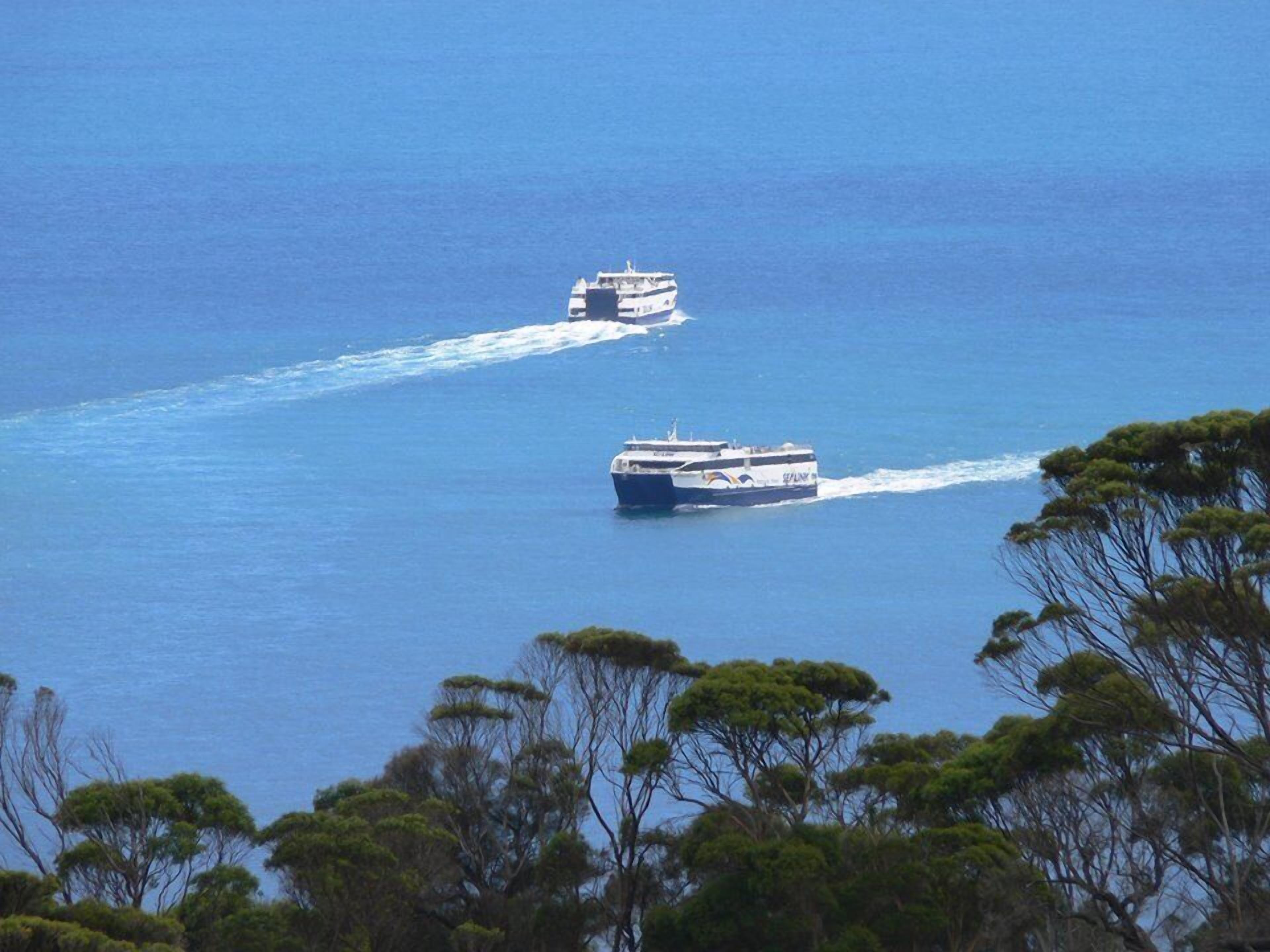 Two boats on a calm sea with a clear sky.