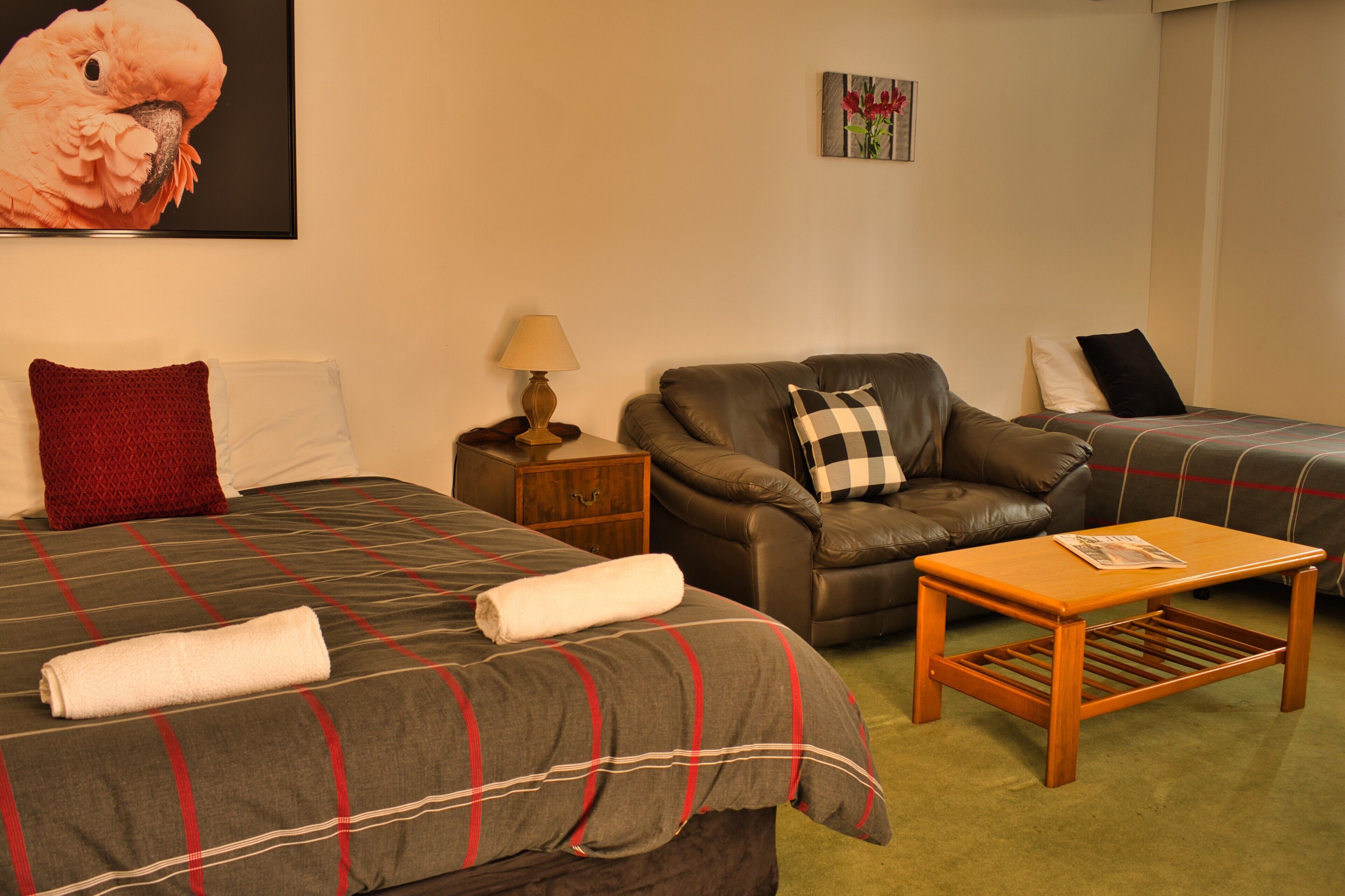 Ein Hotelzimmer mit einem Bett, einer Couch, einem kleinen Tisch, einem Nachttisch und einer Lampe.