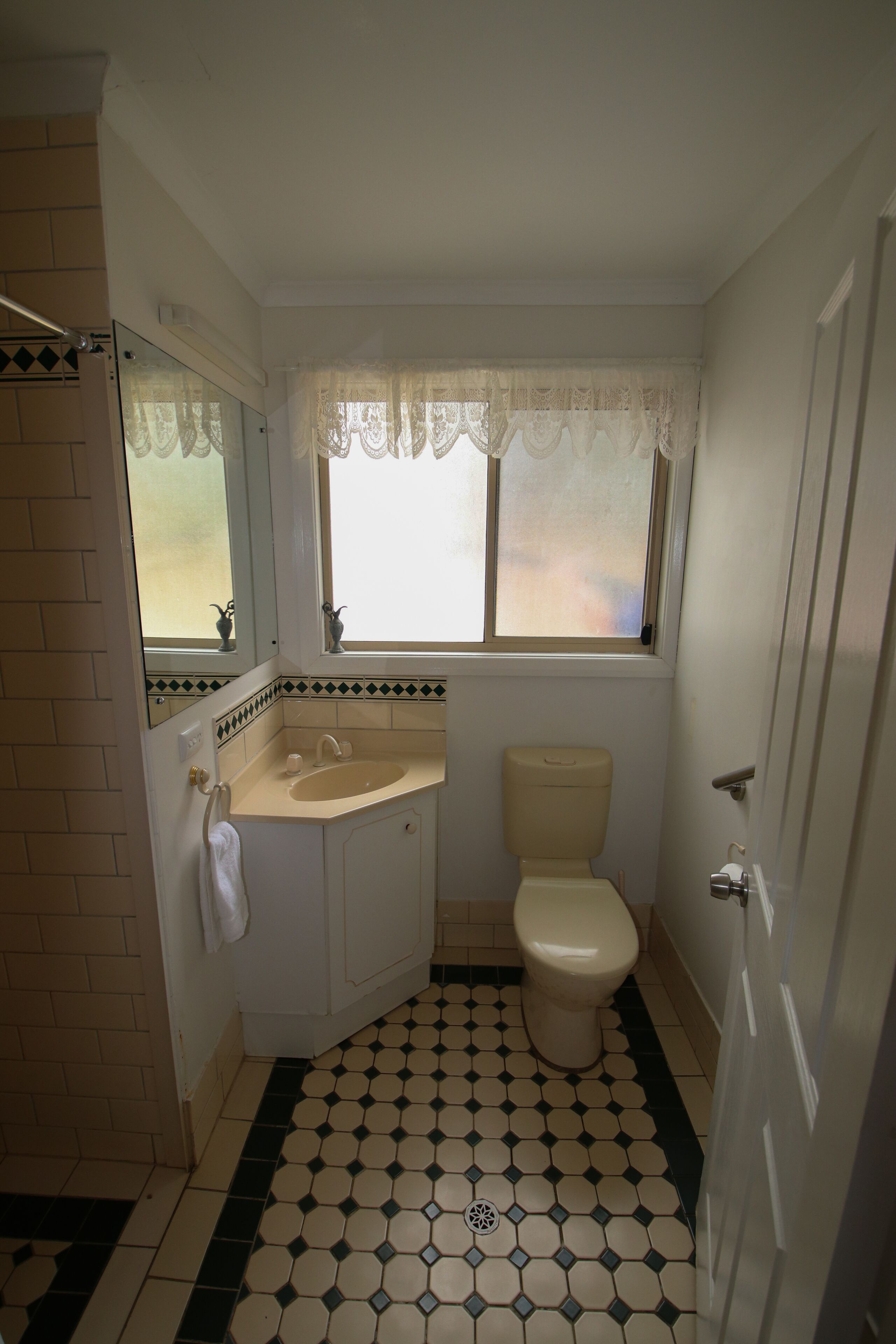 Un baño con inodoro, lavamanos y ventana.